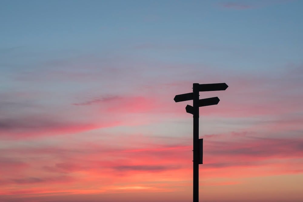 A silhouetted street sign at sunset.