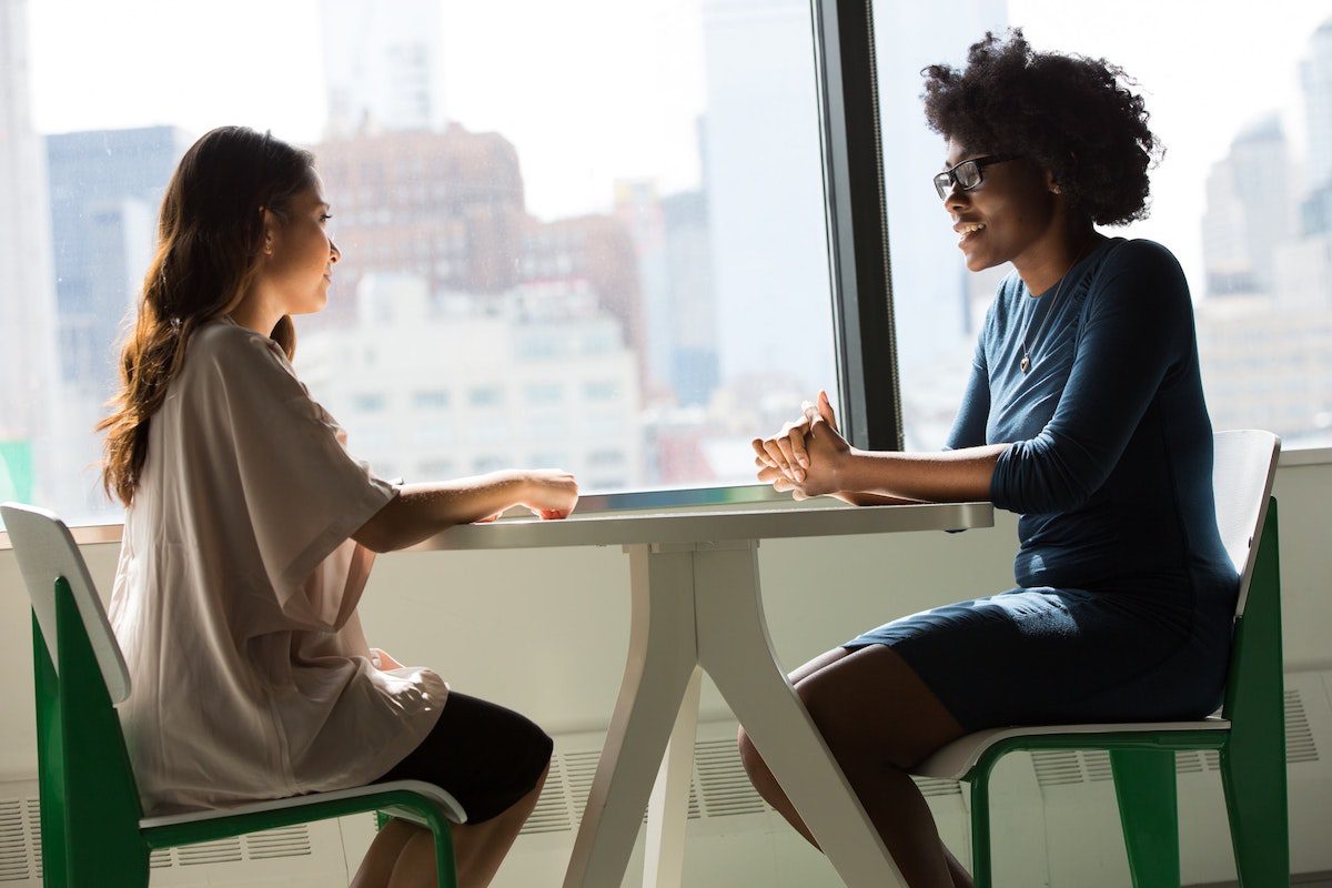 An applicant sitting across the table from the intern hiring manager for an interview. How To Get An Internship At Cognizant